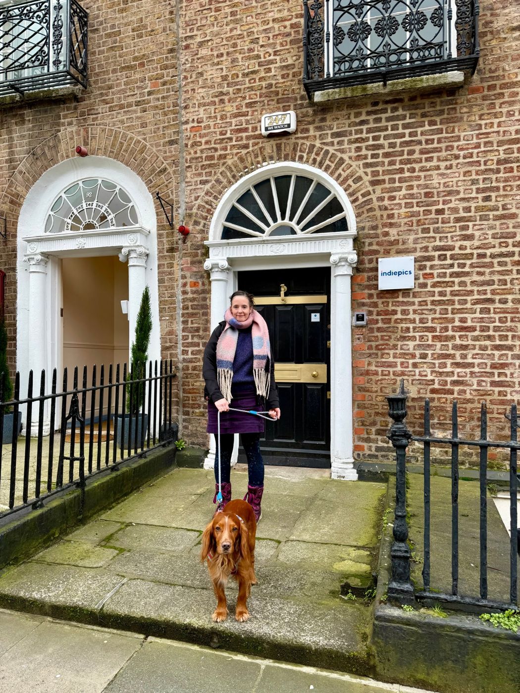 Hilary on a doorstep with a red setter on a lead